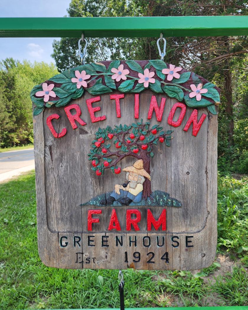 The hand-carved Cretinon Farm Greenhouse sign, established 1924, hanging at the entrance to the farmstand on Landing Road